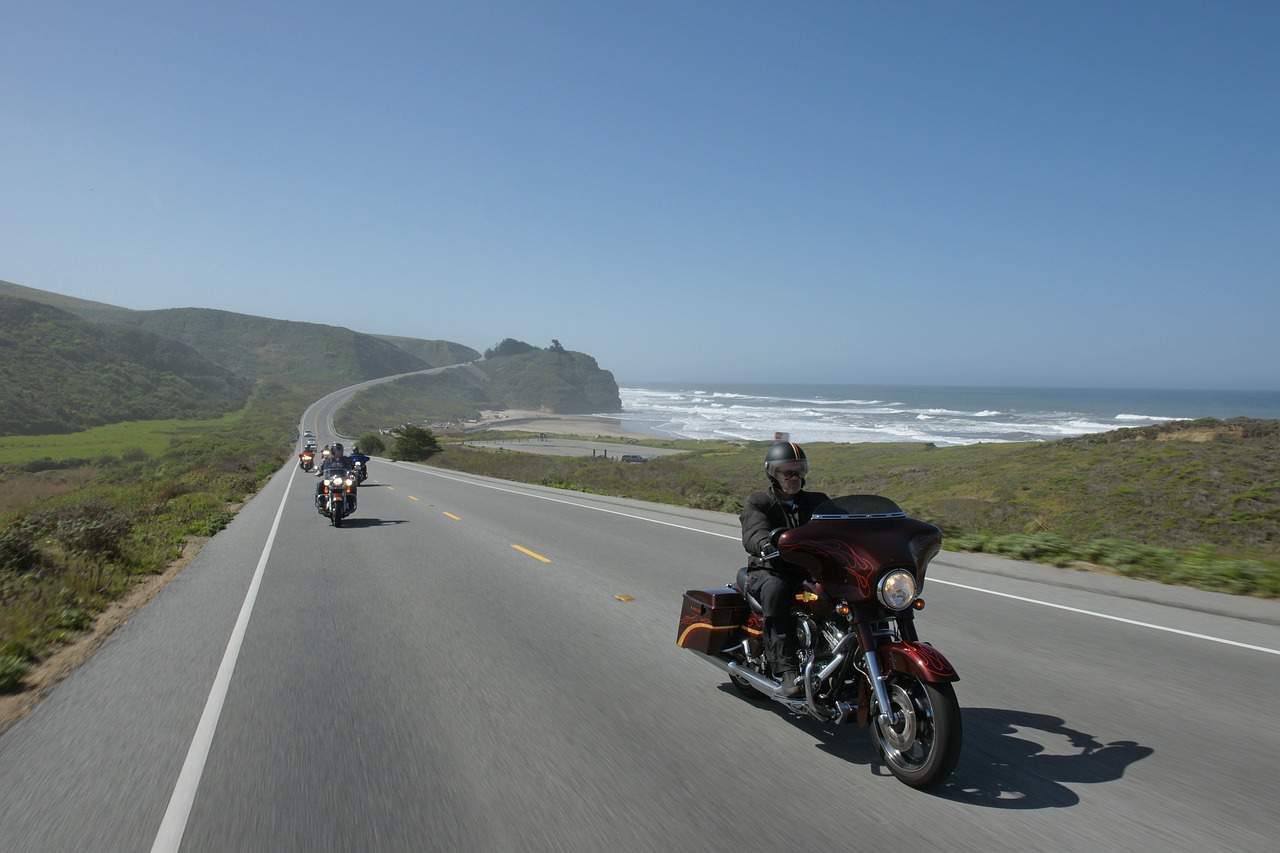 This is a picture of multiple Harley Davidson motorcycles riding along the Pacific Coast Highway in California.